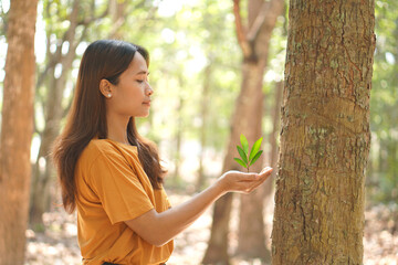 concept of saving the world Asian woman holding a small tree