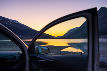 Car parked on lake shore at twilight. Concept of travel, road trip.