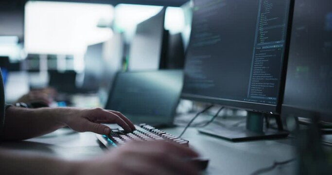 Close Up of a Software Developer Working on a Computer, Typing Programming Code on a Stylish Keyboard with Neon Backlight. Professional Employee Doing Work in a Cyber Security Technology Company