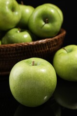 Delicious ripe green apples on black background