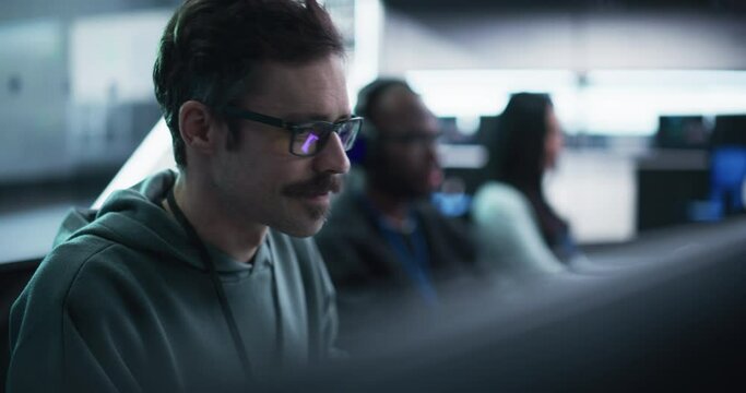 Portrait of a Happy Mustachioed Computer Science Team Member Working on a Computer in a Research and Development Technological Center Facility. Smiling Man Writing Code for Industrial Software