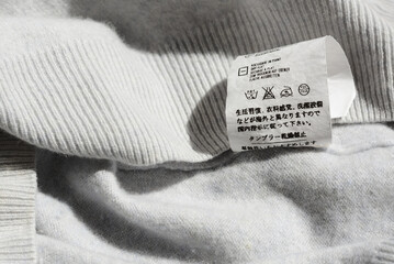 Clothing label with instruction on white garment, closeup