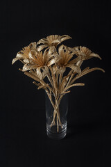 A glass vase with a bouquet of flowers made from straw 