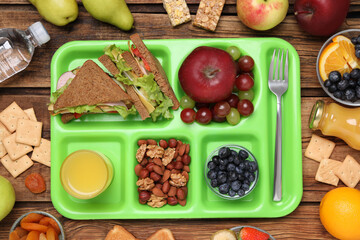 Flat lay composition with serving tray, tasty healthy food on wooden table. School dinner
