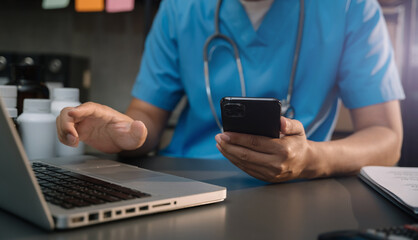 Healthcare And Medicine. Doctor using a digital smartphone and laptop computer.