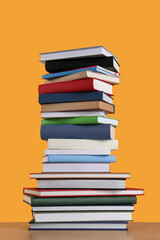 Stack of hardcover books on orange background