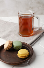 Colorful french macarons or macaroons (almond cookies) with a cup of tea on the  white background. Copy space for text