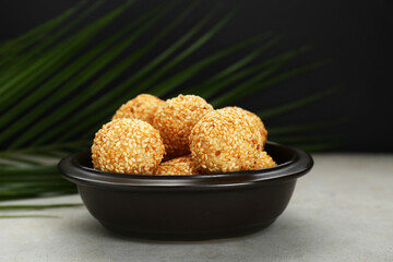 Many delicious sesame balls on textured table