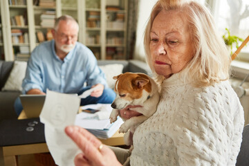 Alte Frau blickt besorgt auf eine Rechnung oder Kassenzettel