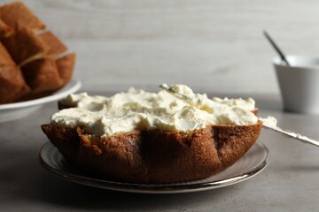 Slice of delicious Pandoro cake with cream on grey table