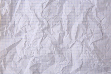 Sheet of crumpled checkered paper as background, top view