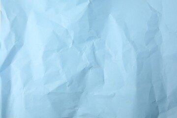 Sheet of crumpled light blue paper as background, top view