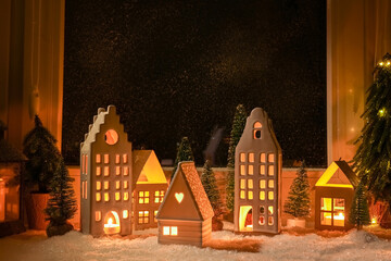 Fototapeta na wymiar House shaped lanterns and Christmas decor on windowsill indoors