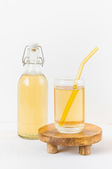 Homemade kombucha fermented drink in glass and bottle on white