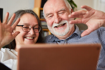 Senioren Paar winkt glücklich beim Videochat