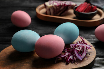 Naturally painted Easter eggs on black wooden table, closeup. Red cabbage used for coloring