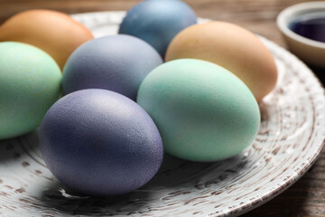 Easter eggs painted with natural organic dyes on wooden table, closeup