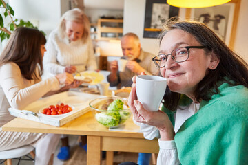 Seniorin und Freunde beim Brunch mit Kaffee