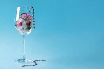 Elegant jewelry. Stylish presentation with luxury earrings, bracelets and frozen roses in glass on light blue background. Space for text