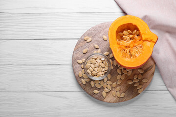 Fresh pumpkin and vegetable seeds on white wooden table, top view. Space for text