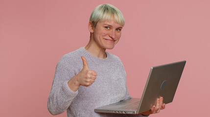 Excited happy millennial woman with short hair typing on laptop computer, working on project,...