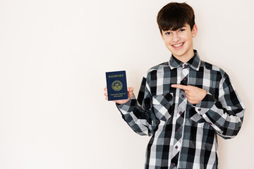 Young teenager boy holding Micronesia passport looking positive and happy standing and smiling with a confident smile against white background. - obrazy, fototapety, plakaty