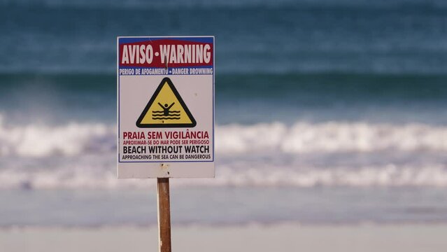 Beach without watch warning sign, ocean or sea waves in background, Portugal signboard