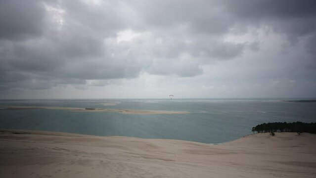 Biggest sand dune du pilat in France, one person paragliding, bad weather wide angle view