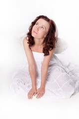 Obraz premium Portrait of a red-haired woman in a white dress lying in the studio. Hope