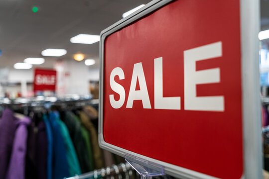 Sale Sign On Rail in Clothes Shop or Store