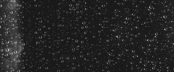 Atmospheric minimal grayscale backdrop with rain droplets on glass. Wet window with rainy drops and dirt spots closeup. Blurry minimalist monochrome background of dirty window glass with raindrops.