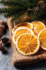 Obraz na płótnie Canvas Dry orange slices, cones and fir tree branches on grey table, closeup