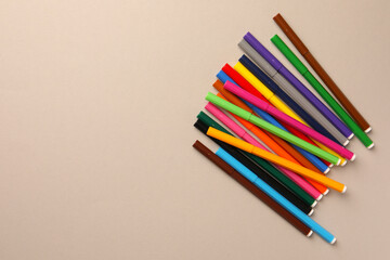 Many bright markers on light grey background, flat lay. Space for text