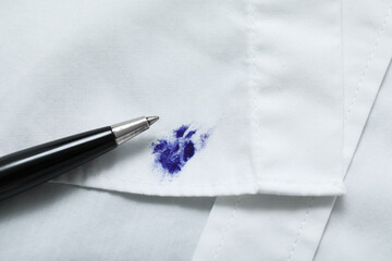 Pen and stain of blue ink on white shirt, closeup. Space for text