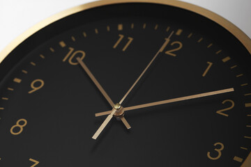 Stylish round clock on white background, closeup. Interior element
