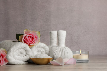 Fototapeta na wymiar Composition with spa products, roses and candle on grey wooden table. Space for text