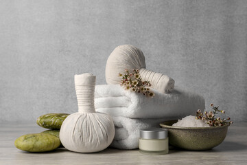 Composition with spa products and flowers on grey wooden table. Space for text