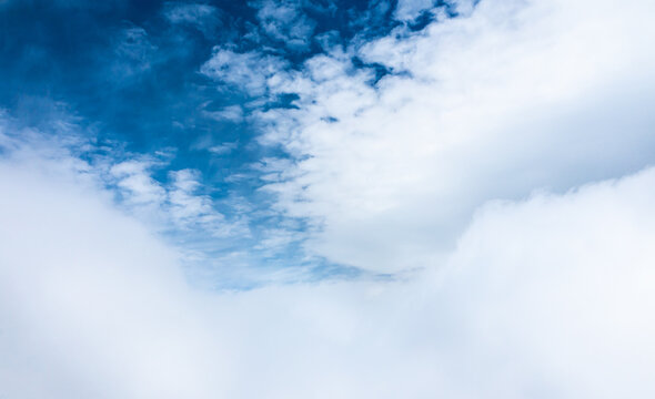 Aerial view through the clouds. Amazing blue sky and cumulus cumulonimbus white clouds landscape great for wallpapers and background.