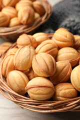 Bowls of delicious nut shaped cookies on white wooden table, closeup