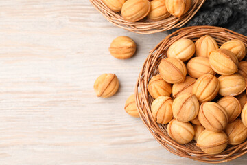 Bowls of delicious nut shaped cookies on white wooden table, flat lay. Space for text