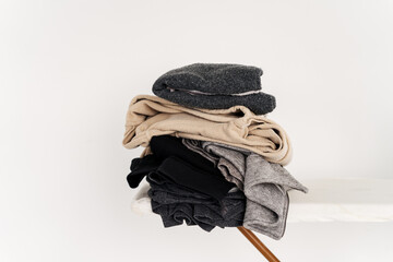 Stack of clothes on ironing board. Concept of housework, ironing, care and storage of things