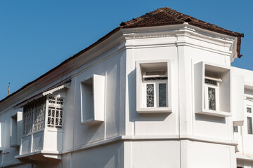 Obraz premium Rectangular windows on the white walls of a vintage Portuguese era building in the Altinho area of Panaji.