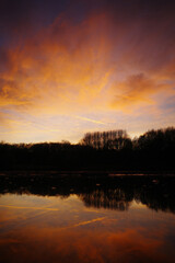 Fototapeta na wymiar Fiery sunset sky over a lake