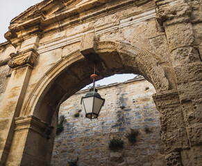 Fototapeta premium Historic stone triumphal arch. Entrance to the castle with an antique lamp
