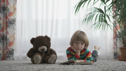 portrait of Beautiful blond hair child  whit head on hands and teddy bear toy