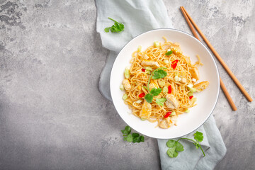 Stir fried noodles with chicken and vegetable in white bowl
