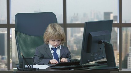 Portrait of handsome little businessman with suit and tie typing at keyboard at office, window city panorama, future success