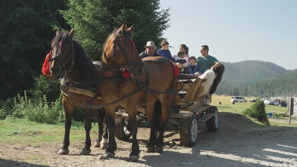 family in carriage with horses, mountain landscape