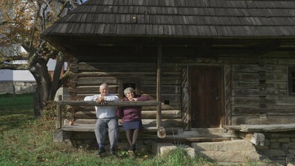 Obraz na płótnie Canvas Seniors couple relax and enjoy time together on wooden rustic house porch