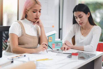 Obraz premium Construction and architect home building company concept, Engineers, architects and designers work together to design home or resident housing and validate blueprints in the workplace.